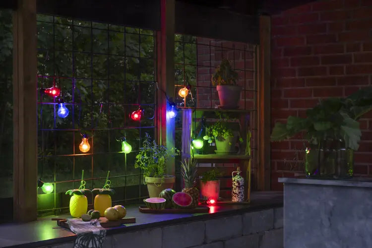 Terras verlicht met meerkleurige lampjes bij avondlicht
