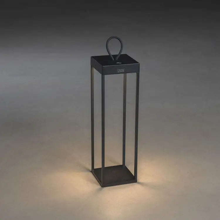Konstsmide Ravello terraslamp vanuit een hoek gezien, verlicht op een donkere achtergrond