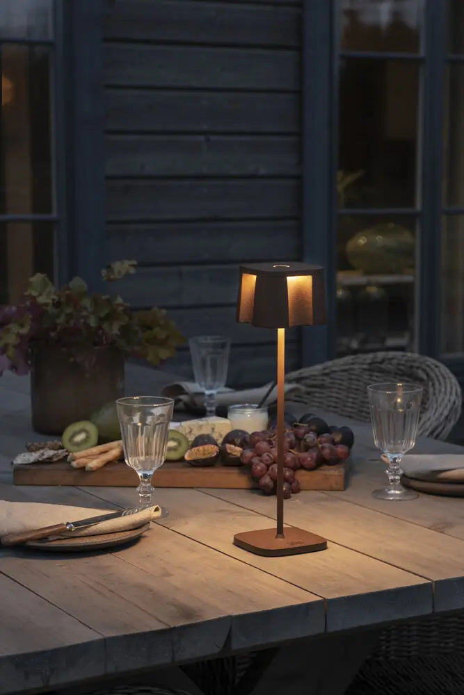 Konstsmide Nice tafellamp op een gedekte tafel bij avondlicht, ander perspectief