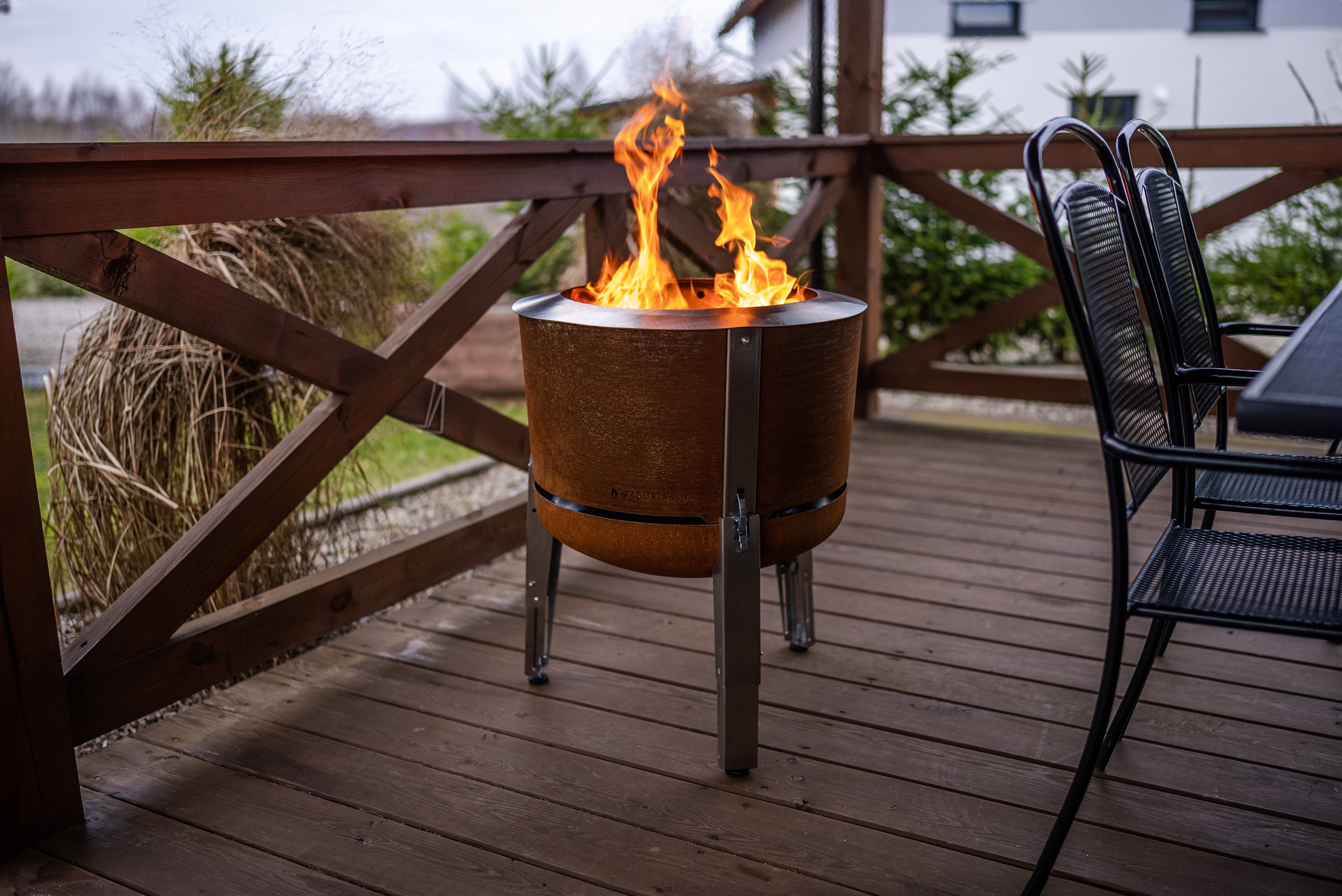 Alpha 600 Corten vuurkorf op terras met tuinmeubelen en brandende vlam