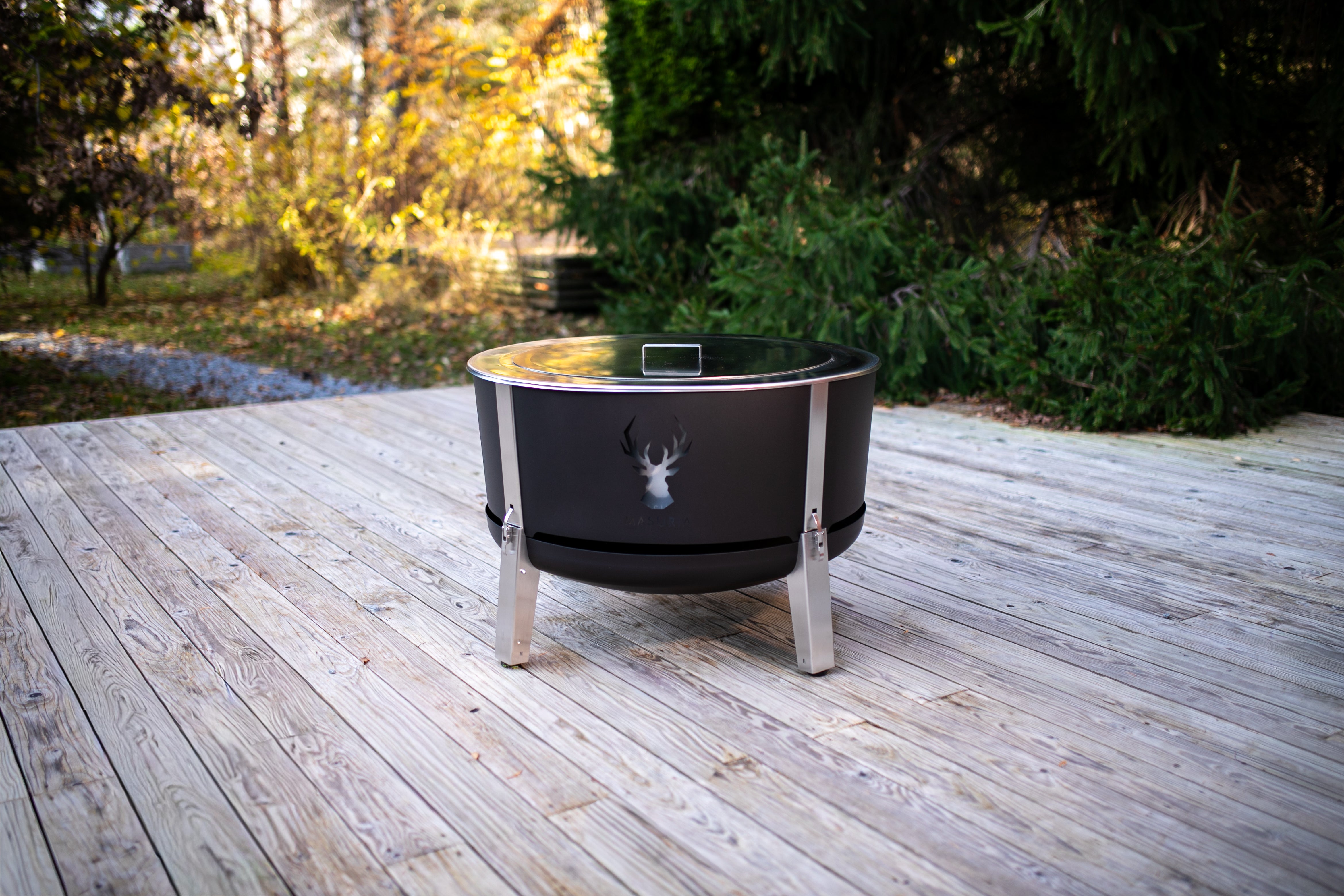 Alpha 800 Zwart Tuinset bundel – vuurkorf met deksel op houten terras in herfstomgeving