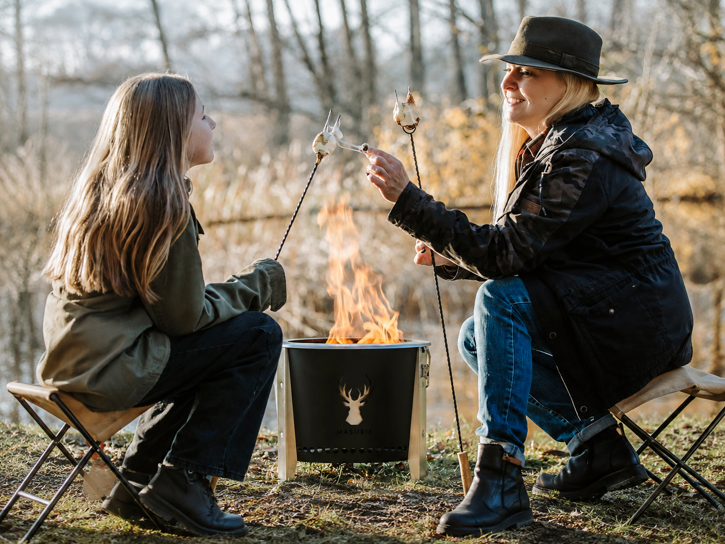 Stel zit samen bij de Alpha Camp Zwart rookloze vuurkorf in campingstoelen buiten