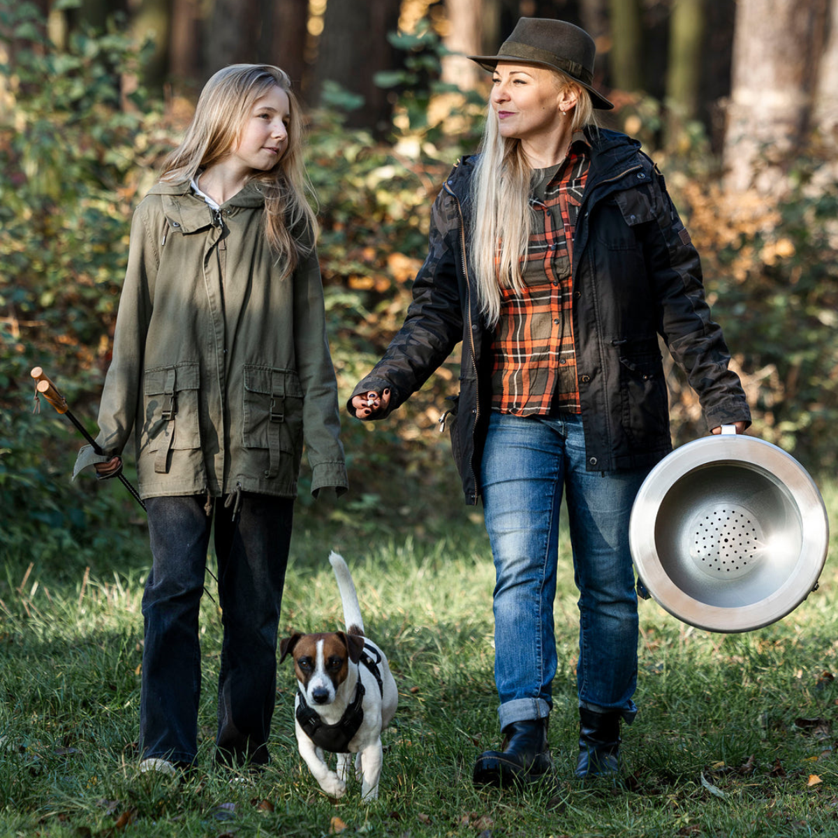 Stel wandelt met hond en draagt deksel van de Alpha Camp Zwart vuurkorf