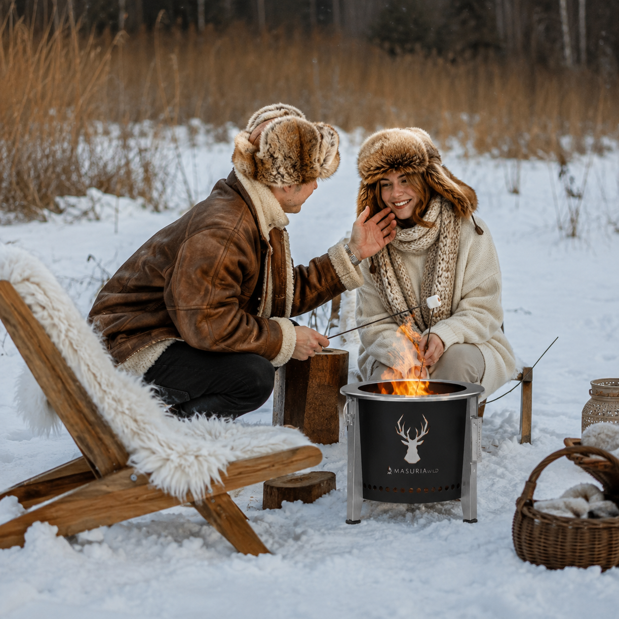 Vrouw voegt hout toe aan de Alpha Camp Zwart vuurkorf in winteromgeving