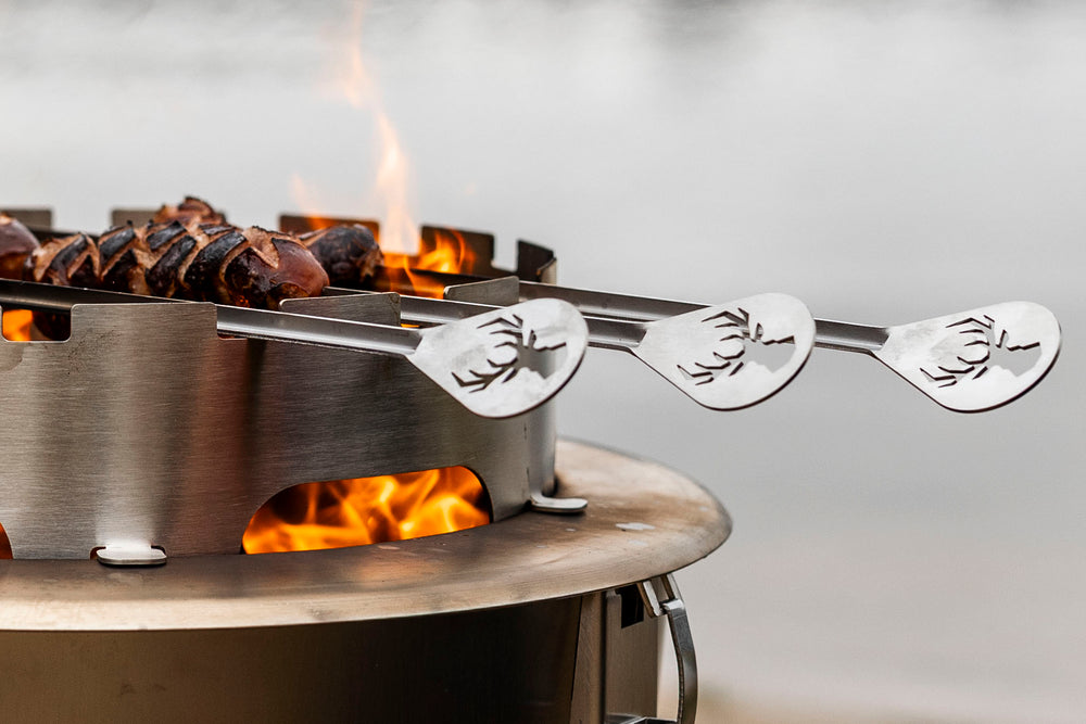 Alpha Camp Corten Cook Kit – vuurkorf met skewer rack en eten boven het vuur