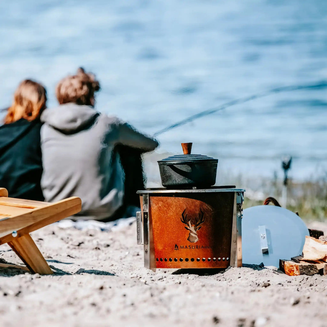 Persoon geniet buiten aan het meer bij de Alpha Camp Corten rookloze vuurkorf