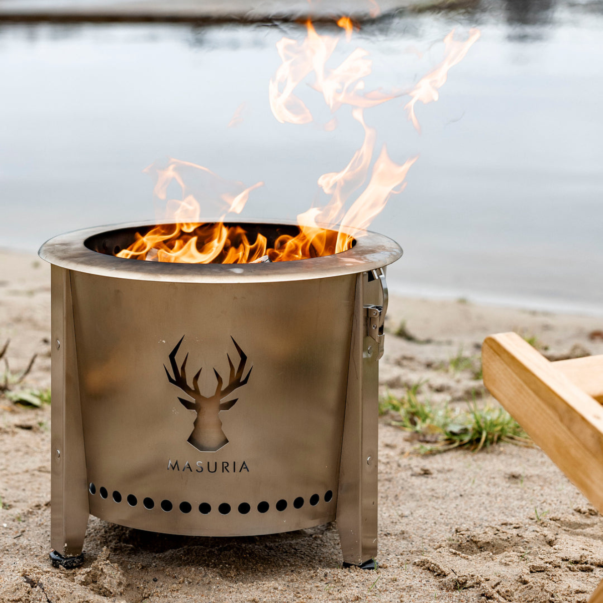 Alpha Camp Zilver rookloze vuurkorf brandend aan het water overdag – lifestyle