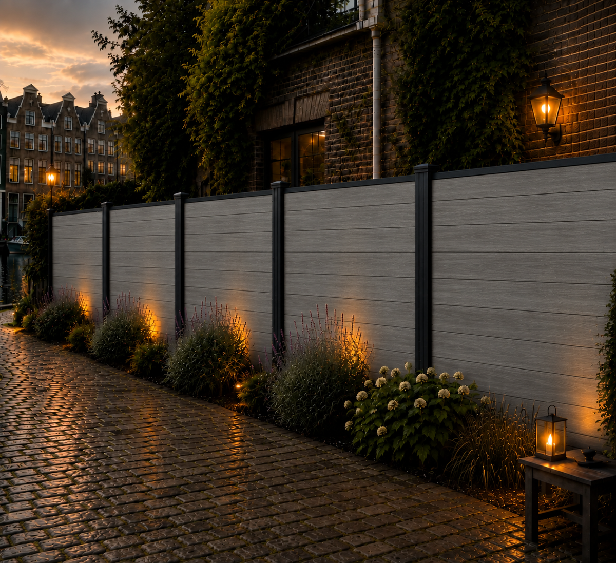 Grijze composiet schutting langs keienpad met lavendel en hortensia's