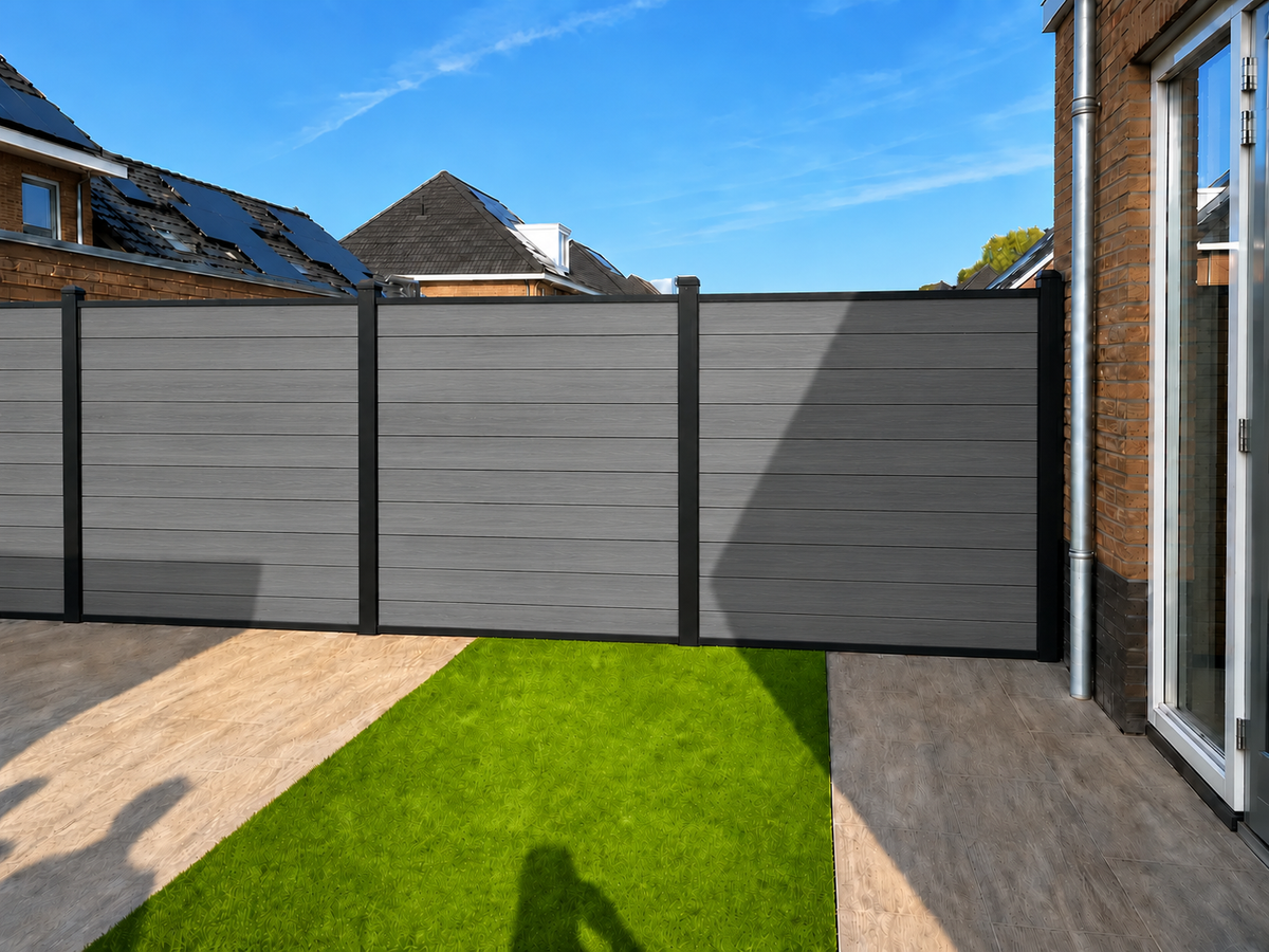 Grijze composiet schutting rond tuin met kunstgras en terras