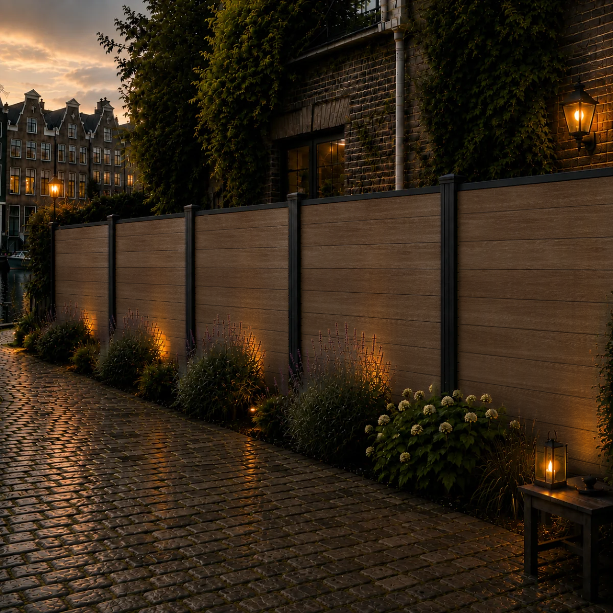 Teakkleurige composiet schutting langs keienpad met lavendel en hortensia's