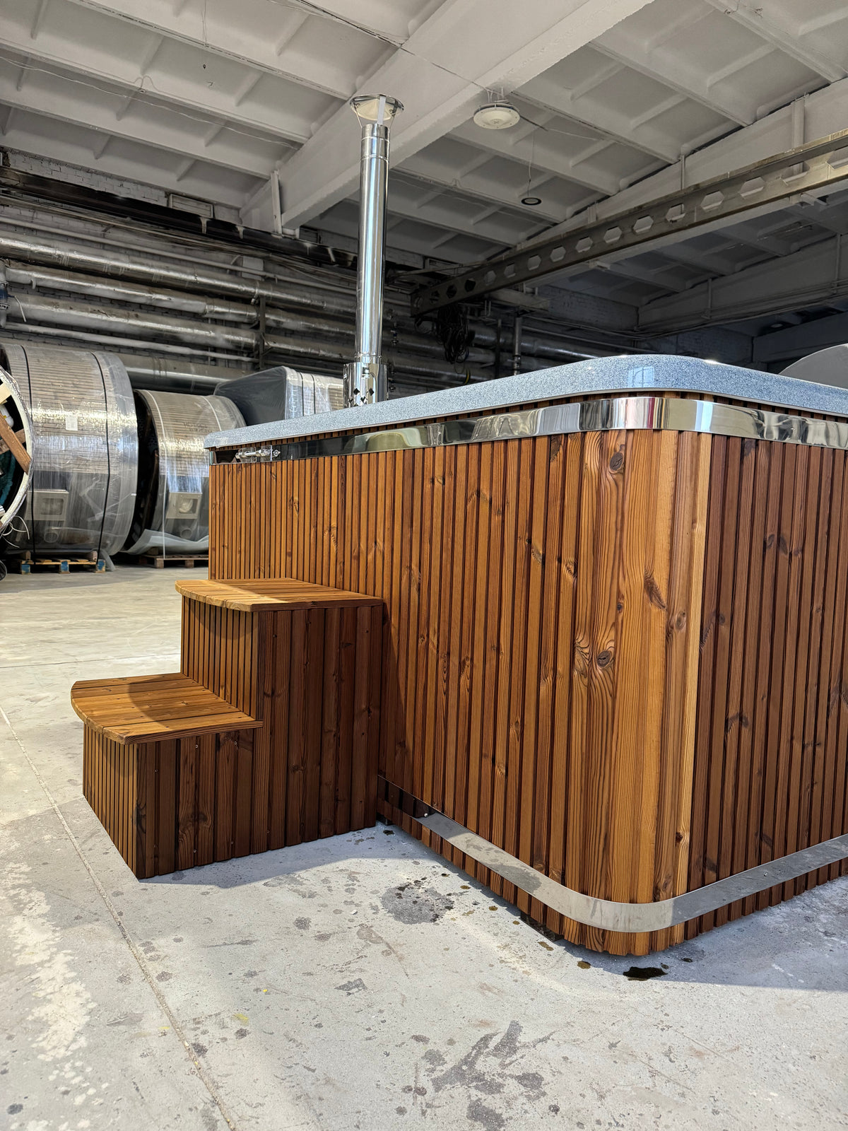 Quadro Hot Tub met houten bekleding en opstaptrap in een showroom