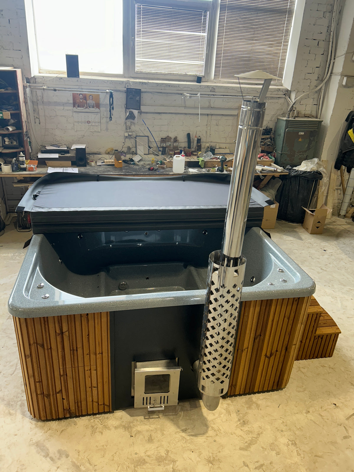 Quadro Hot Tub met geïsoleerde deksel en opstaptrap in een showroom