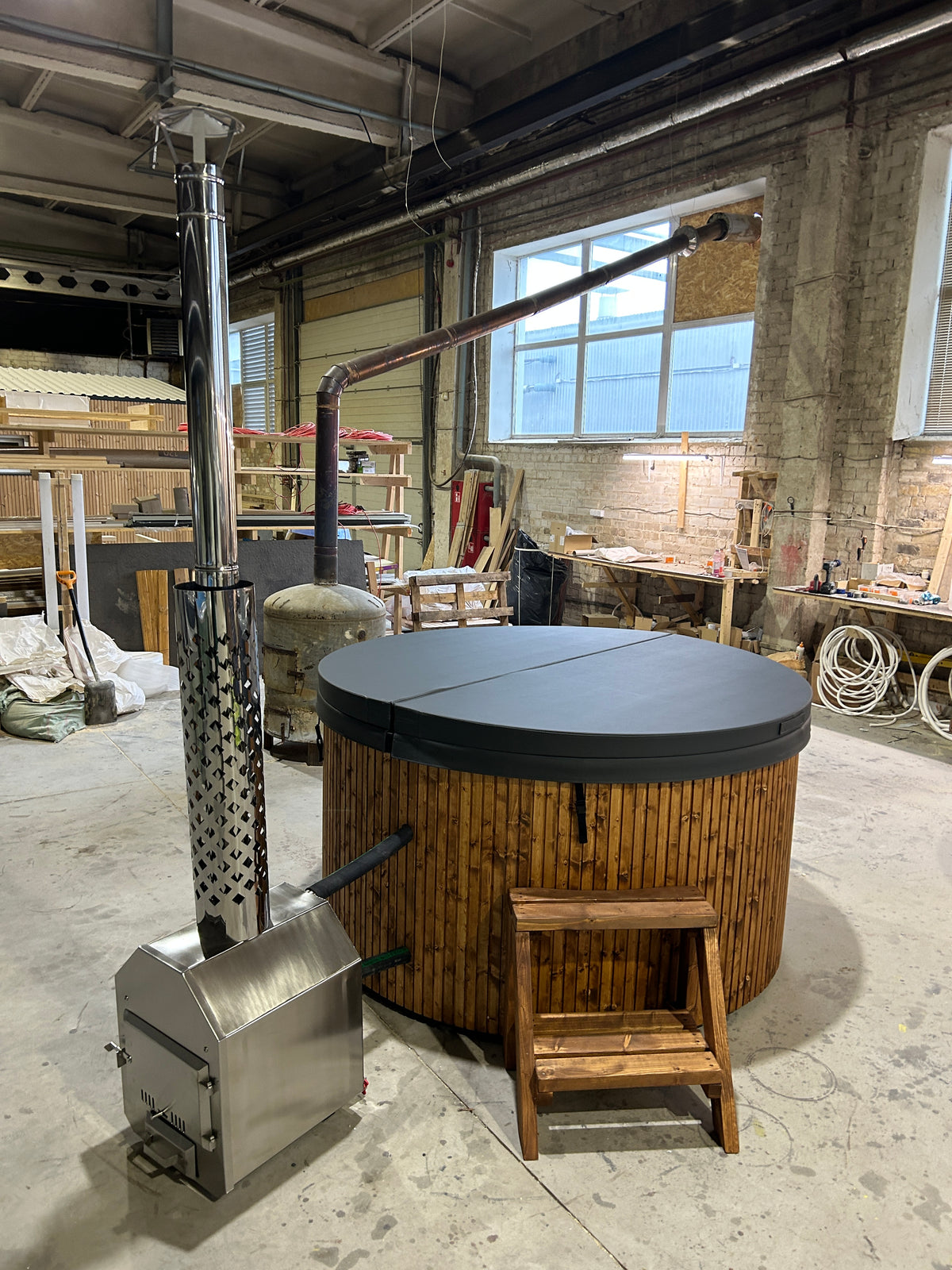 Houtgestookte Hot Tub met externe kachel en gesloten deksel in een showroom
