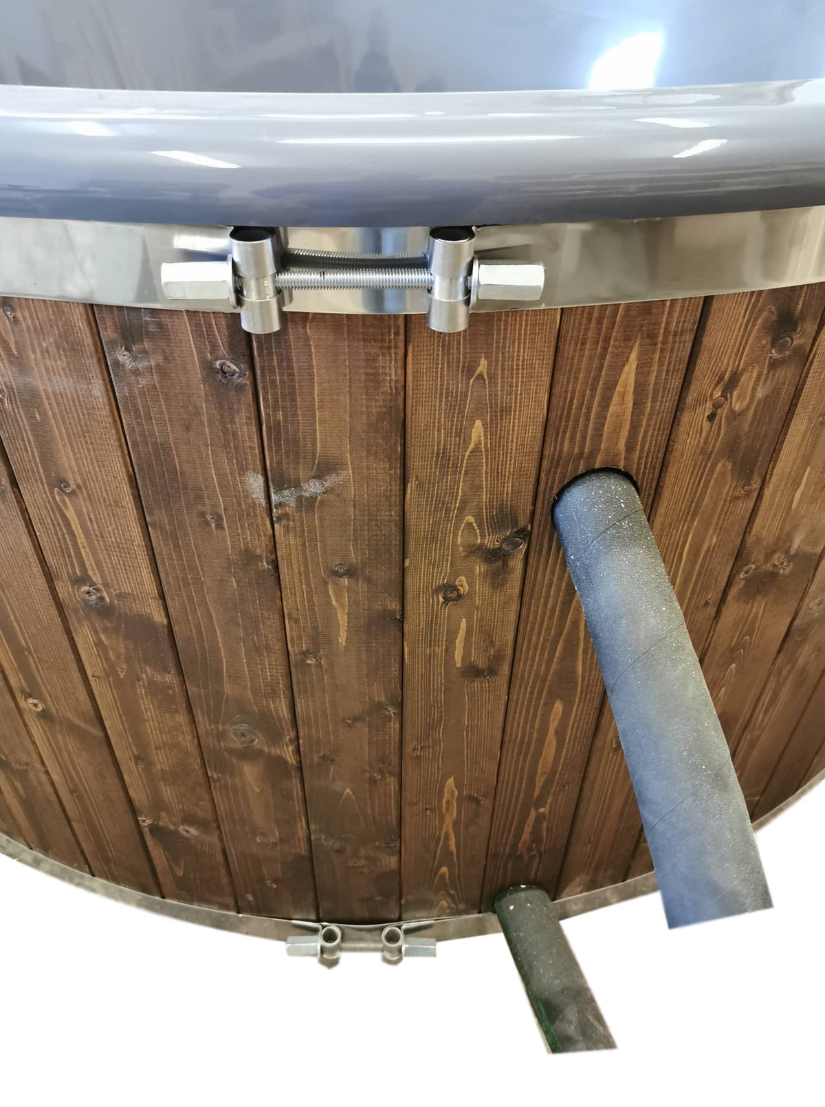 Close-up van de houten bekleding met de aansluitleidingen van de externe kachel