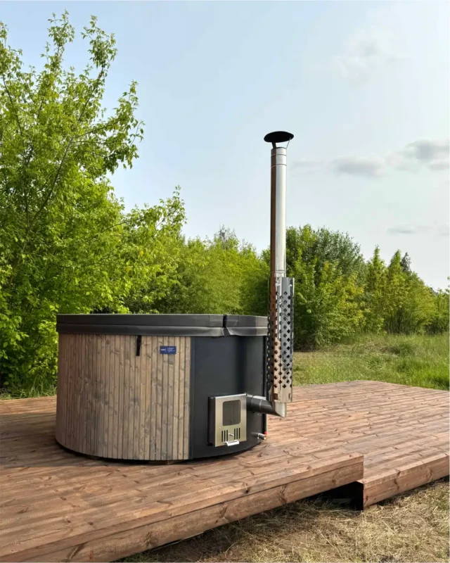 Houtgestookte Hot Tub met rookpijp op een houten terras in de tuin