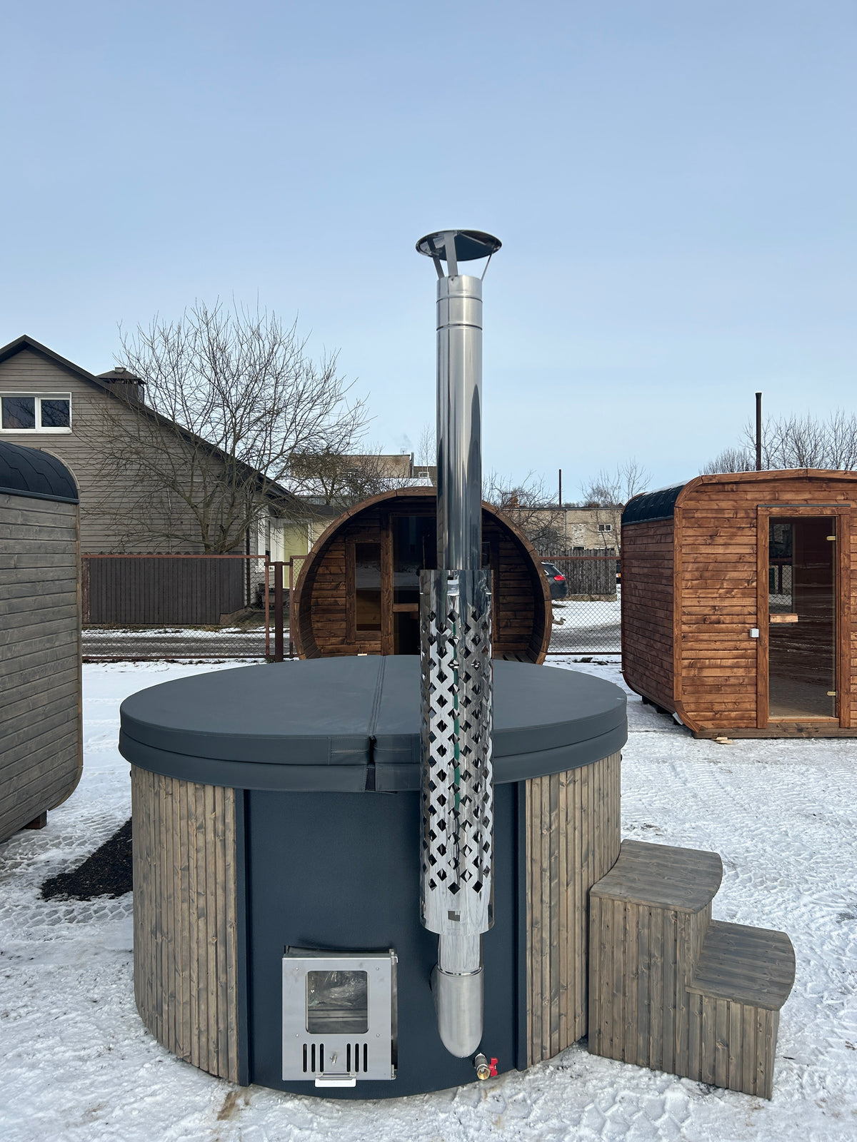 Houtgestookte Hot Tub met rookpijp in de tuin naast een woning