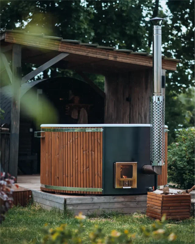 Houtgestookte Hot Tub met rookpijp naast een tuinhuis