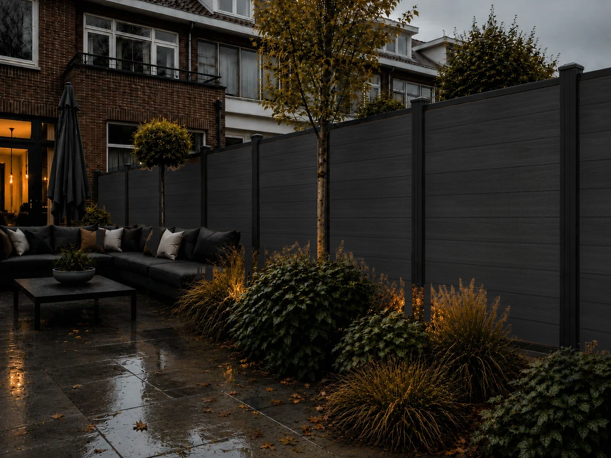 Zwarte composiet schutting in de tuin bij avondverlichting