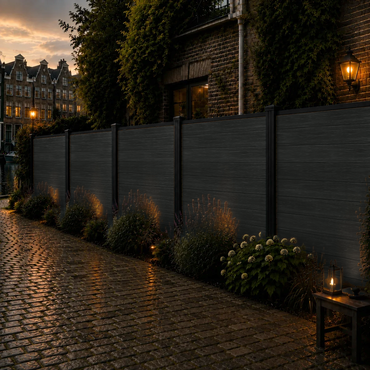 Zwarte composiet schutting langs keienpad met lavendel en hortensia's
