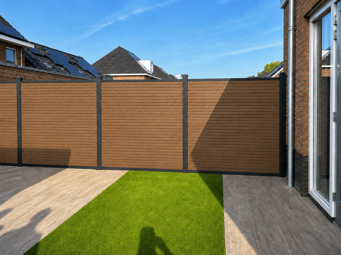 Composiet schutting teak in achtertuin met kunstgras en terras